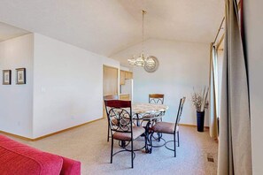 Un coin repas avec une table ronde, quatre chaises et un lustre.