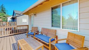 Eine Holzterrasse mit Sitzgelegenheiten und einem überdachten Bereich.