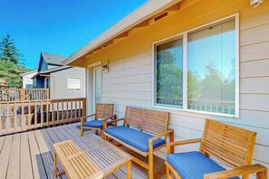 Eine Holzterrasse mit Sitzgelegenheiten und einem überdachten Bereich.