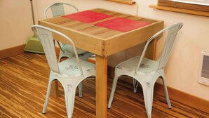 A small dining area with a wooden table and two white chairs. - Micro-Loft Surrounded by Gardens in Hip Location (Portland)