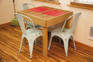 Ein kleiner Essbereich mit einem Holztisch und zwei weißen Stühlen.