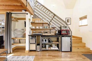 A compact kitchen with a built-in microwave, a coffee machine, and a refrigerator. - Micro-Loft Surrounded by Gardens in Hip Location (Portland)