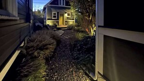 A residential property with a pathway leading to a house, surrounded by vegetation. - Micro-Loft Surrounded by Gardens in Hip Location (Portland)
