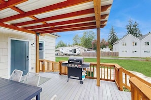 A covered deck with a grill, outdoor seating, and a view of a residential neighborhood. - 3 BR - Downtown Newberg - Wine Tasting - WiFi (Newberg)
