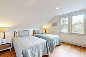 A bedroom with two beds, a nightstand with a lamp, and a large window. - 3 BR - Downtown Newberg - Wine Tasting - WiFi (Newberg)