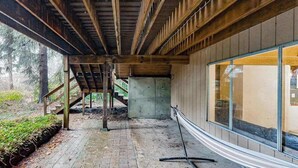 An interior space with a wooden ceiling, a concrete column, and a glass wall. - 2BR cabin with loft in wooded setting with WiFi (Beaverton)