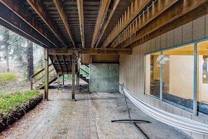 Ein Innenraum mit Holzbalkendecke, einer Betonstütze und einer Glaswand.