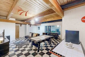 A room with a checkered floor, a billiards table, a sofa, a television, and a Coca-Cola sign on the wall. - 2BR cabin with loft in wooded setting with WiFi (Beaverton)