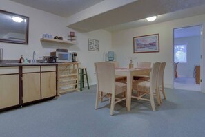 A compact kitchen with a dining area, including a microwave, sink, and cabinets. - Cheery 2BR Golf Course View Oregon Wine Country (McMinnville)