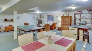 A room with a ping pong table, a dining table, a kitchen area, and a seating area with chairs. - Cheery 2BR Golf Course View Oregon Wine Country (McMinnville)