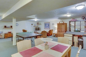 A room with a ping pong table, a dining table, a kitchen area, and a seating area with chairs. - Cheery 2BR Golf Course View Oregon Wine Country (McMinnville)