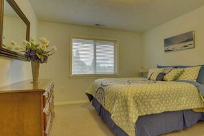 A bedroom with a bed, dresser, window with blinds, and a painting on the wall. - Cheery 2BR Golf Course View Oregon Wine Country (McMinnville)