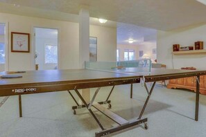 A ping pong table in a room with a white ceiling, a door, and a window. - Cheery 2BR Golf Course View Oregon Wine Country (McMinnville)