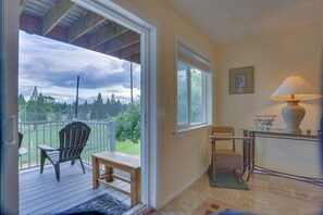 A room with a wooden deck, a chair, a table, and a lamp. - Cheery 2BR Golf Course View Oregon Wine Country (McMinnville)
