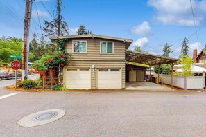 A two-story house with a garage, a stop sign, and a street sign. - Delightful 2BR Lakefront - Patio (Lake Oswego)