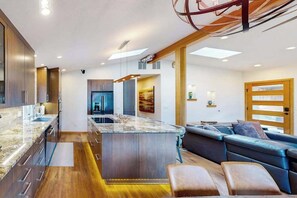 A modern kitchen with a central island, wooden cabinets, and a built-in oven. - Delightful 2BR Lakefront - Patio (Lake Oswego)
