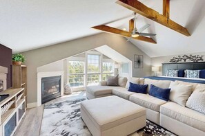 A spacious living room with a high ceiling, a fireplace, a large sofa set, and a ceiling fan. - High-End Rooftop Studio Oregon Wine Country (McMinnville)