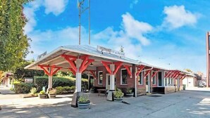 Un bâtiment doté d’un espace extérieur abrité, d’une enseigne indiquant la présence d’un restaurant et d’un ciel dégagé.
