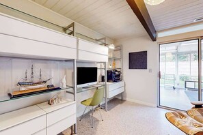 Ein modernes Wohnzimmer mit einem Glastisch, einem Schiffsmodell, einem Flachbildfernseher und einem Sofa.