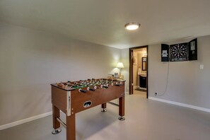 Uma mesa de futebol de mesa em um quarto com um alvo de dardos na parede.