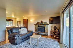 A living room with a fireplace, a sofa, a coffee table, and a flat-screen TV. - Wine Country 3BR Mountainview Oregon Wine Country (Dundee)