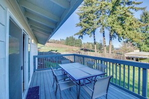 A covered outdoor deck with a table and chairs, overlooking a forested area. - Wine Country 3BR Mountainview Oregon Wine Country (Dundee)