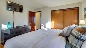 Una camera da letto con un letto, una cassettiera, una televisione e un armadio.