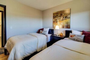 A hotel room with two beds, a nightstand with a lamp, and a painting on the wall. - Wine Country 3BR Mountainview Oregon Wine Country (Dundee)