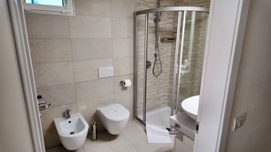 A modern bathroom with a bidet, a toilet, and a glass-enclosed shower. - Residenza Francesca Luxury Suite (Riva del Garda)