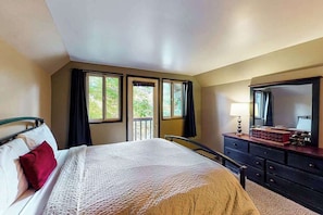 A bedroom with a bed, a dresser, a mirror, and windows with curtains. - 3BR Mountainview Dog Friendly (Leavenworth)