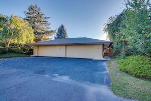 A single-story building with a garage, surrounded by trees and a driveway. - Renovated 3BR Mountainview - Pool - Hot Tub (Manson)