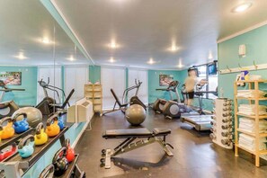 A gym with exercise equipment, a treadmill, and a person working out. - Renovated 3BR Mountainview - Pool - Hot Tub (Manson)