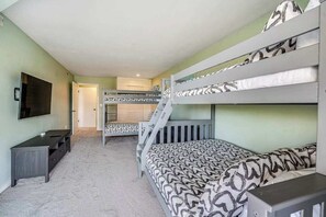 A room with bunk beds, a television, a desk, and a carpeted floor. - Renovated 3BR Mountainview - Pool - Hot Tub (Manson)