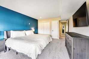 A bedroom with a bed, a dresser, a TV, and a wardrobe. - Renovated 3BR Mountainview - Pool - Hot Tub (Manson)