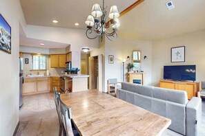 A modern living room with a dining table, sofa, and a television. - Downtown 1BR Mountainview 2nd-Floor - Balcony (Leavenworth)