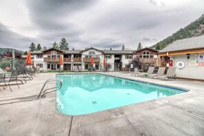 A hotel with a swimming pool, outdoor seating, and a mountain backdrop. - Downtown 1BR Mountainview 2nd-Floor - Balcony (Leavenworth)