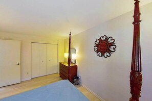 A bedroom with a bed, a dresser, a wall-mounted decorative item, and a door. - 2BR Lakeview - Patio - Washer/Dryer (Chelan)