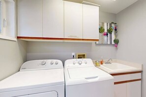 Ein Waschraum mit zwei weißen Whirlpool-Waschmaschinen und einem Waschbecken.