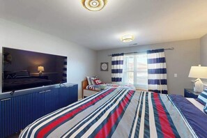 A hotel room with a bed, a TV, a desk, and a window with curtains. - Spacious 6BR - Pool - Hot Tub - Deck (Manson)