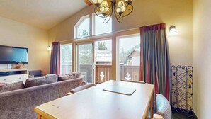 A cozy living area with a wooden table, sofas, and a television. - 1 BR condo located in Icicle Village, Leavenworth (Leavenworth)