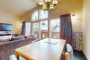 A cozy living area with a wooden table, sofas, and a television. - 1 BR condo located in Icicle Village, Leavenworth (Leavenworth)