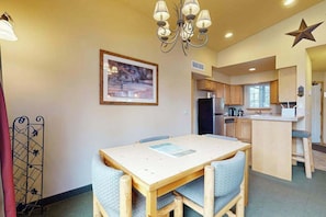A compact kitchen with wooden cabinets, a refrigerator, and a small island with a sink. - 1 BR condo located in Icicle Village, Leavenworth (Leavenworth)