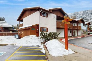 A hotel with a snow-covered parking area and a signpost indicating amenities. - 1 BR condo located in Icicle Village, Leavenworth (Leavenworth)