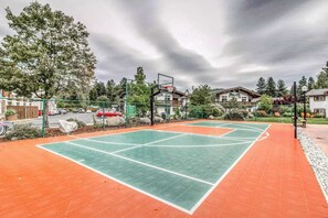 An outdoor basketball court with a green and orange surface, surrounded by trees and residential buildings. - 1 BR condo located in Icicle Village, Leavenworth (Leavenworth)