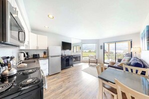 A modern kitchen with a dining area, large windows, and a view of the outdoors. - Bright 1BR Lakefront - Patio - Pool (Chelan)