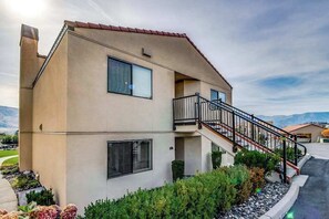 A two-story building with a balcony, a staircase, and a landscaped garden area. - Bright 1BR Lakefront - Patio - Pool (Chelan)