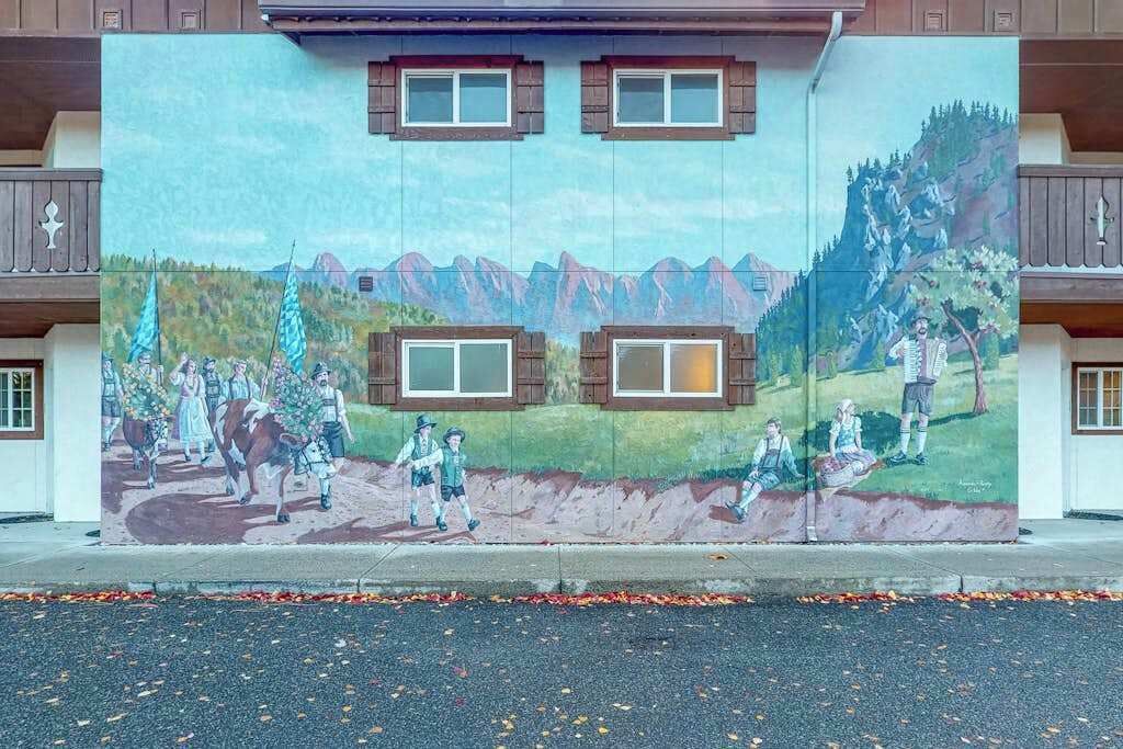 Un mural en la fachada de un edificio que muestra una escena rural con gente y animales.