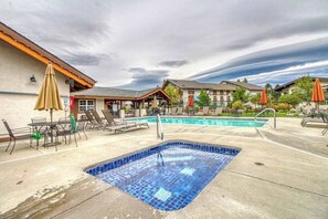 Ein Hotelpoolbereich mit Whirlpool, Liegestühlen und Sonnenschirmen.