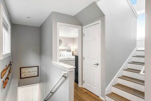 A hallway with a white door, a staircase, and a framed welcome sign. - Large 2BR Lakefront - Hot Tub - Dock - Patio (Chelan)
