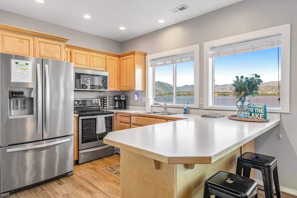 A modern kitchen with stainless steel appliances, wooden cabinets, and a large island.